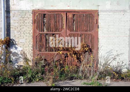 Altes Holztor in einem verlassenen Industriegebiet. Stockfoto