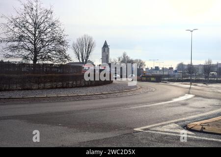 Kreisverkehr mit einem Glockenturm und einer Tankstelle daneben in einem Dorf in der italienischen Landschaft Stockfoto