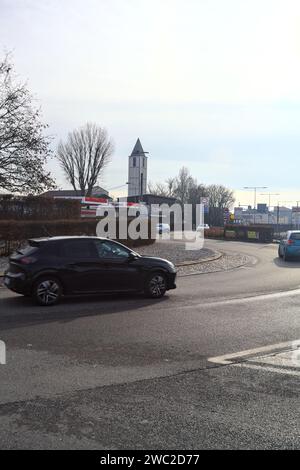 Kreisverkehr mit einem Glockenturm und einer Tankstelle daneben in einem Dorf in der italienischen Landschaft Stockfoto