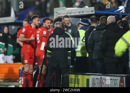 Birkenhead, Großbritannien. Januar 2024. Michael Williamson, der Milton Keynes Dons Manager (c), sieht zu, wie Fans, Spieler und Management um das Dugout des Auswärtsteams streiten. EFL Skybet Football League Two Match, Tranmere Rovers gegen MK Dons im Prenton Park, Birkenhead, Wirral am Samstag, den 13. Januar 2024. Dieses Bild darf nur für redaktionelle Zwecke verwendet werden. Nur redaktionelle Verwendung, .PIC von Chris Stading/ Credit: Andrew Orchard Sportfotografie/Alamy Live News Stockfoto