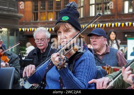 Glasgow, Großbritannien. Januar 2024. Schüler und Tutoren des Glasgow Fiddle Workshop, bekannt als „GFW“, einer schottischen Wohltätigkeitsorganisation, die 1992 als Geigen-Workshop begann, spielten für Reisende im Central Railway Station in Glasgow, Schottland. Der Workshop unterstützt und fördert die Teilnahme an traditioneller Musik und bietet Unterricht in verschiedenen Instrumenten wie Akkordeon, Geige, Banjo und Mandoline. Quelle: Findlay/Alamy Live News Stockfoto