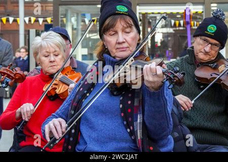 Glasgow, Großbritannien. Januar 2024. Schüler und Tutoren des Glasgow Fiddle Workshop, bekannt als „GFW“, einer schottischen Wohltätigkeitsorganisation, die 1992 als Geigen-Workshop begann, spielten für Reisende im Central Railway Station in Glasgow, Schottland. Der Workshop unterstützt und fördert die Teilnahme an traditioneller Musik und bietet Unterricht in verschiedenen Instrumenten wie Akkordeon, Geige, Banjo und Mandoline. Quelle: Findlay/Alamy Live News Stockfoto