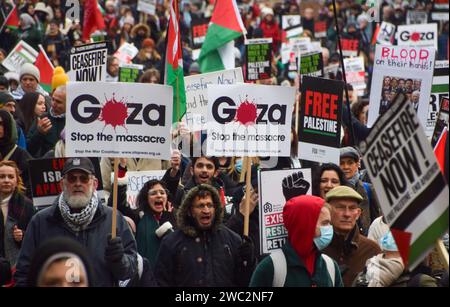 London, Großbritannien. Januar 2024. Die Demonstranten halten während der Demonstration Plakate mit dem Titel "Gaza, stoppt das Massaker". Tausende von Menschen marschierten solidarisch mit Palästina in Zentral-London und forderten einen Waffenstillstand während des Krieges zwischen Israel und der Hamas. Quelle: SOPA Images Limited/Alamy Live News Stockfoto