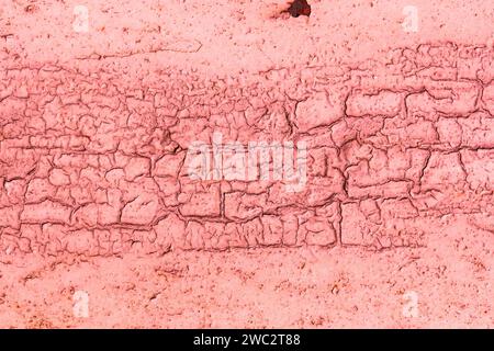 Die Textur der gerissenen alten roten Farbe an der Wand. Abstrakter rosafarbener Hintergrund für ein Design mit Kopierabstand. Stockfoto