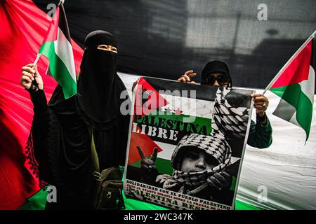 Bangkok, Thailand. Januar 2024. Thailändische Muslime halten während eines Protestes, der zu einem dauerhaften Waffenstillstand im Gazastreifen anlässlich des Globalen Aktionstages für Gaza in der US-Botschaft in Bangkok, Thailand, aufruft, ein "freies Palästina"-Banner und eine palästinensische Flagge. (Kreditbild: © Wissarut Weerasopon/ZUMA Press Wire) NUR REDAKTIONELLE VERWENDUNG! Nicht für kommerzielle ZWECKE! Stockfoto