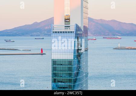 Yeoso, Südkorea: 25. Dezember 2017: Gipfel des MVL-Hotels mit Bergen und dem Hafen voller Binnenschiffe im Hintergrund Stockfoto