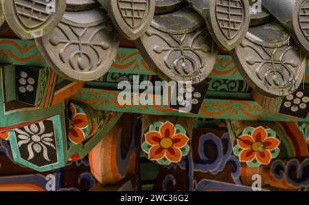 Nahaufnahme einer Ecke des asiatischen Gebäudes mit Keramikfliesen und farbenfrohen Designs Stockfoto