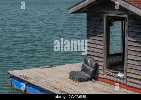 Alte verlassene Fischerhütte und Dock schwimmend auf der Oberfläche des Sees Stockfoto