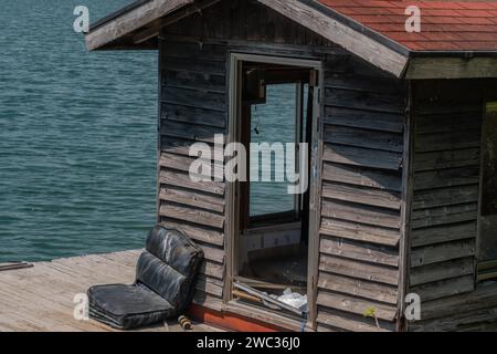 Alte verlassene Fischerhütte und Dock schwimmend auf der Oberfläche des Sees Stockfoto