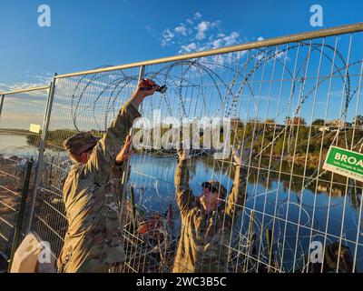 Eagle Pass, Usa. Dezember 2023. Die Nationalgarde der Texas Army befestigt am 19. Dezember 2023 in Eagle Pass, Texas, einen temporären Zaun, der den Zugang zum Rio Grande an der texanisch-mexikanischen Grenze abschließt. Die Soldaten handeln auf Befehl des Gouverneurs von Texas im Rahmen der staatlich geförderten Operation Lone Star. Quelle: 1SG Suzanne Ringle/Texas National Guard/Alamy Live News Stockfoto