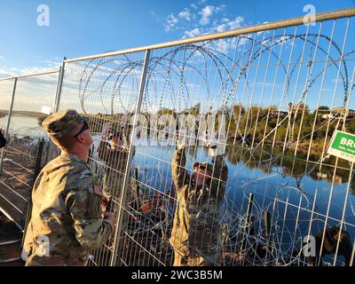 Eagle Pass, Usa. Dezember 2023. Die Nationalgarde der Texas Army befestigt am 19. Dezember 2023 in Eagle Pass, Texas, einen temporären Zaun, der den Zugang zum Rio Grande an der texanisch-mexikanischen Grenze abschließt. Die Soldaten handeln auf Befehl des Gouverneurs von Texas im Rahmen der staatlich geförderten Operation Lone Star. Quelle: 1SG Suzanne Ringle/Texas National Guard/Alamy Live News Stockfoto