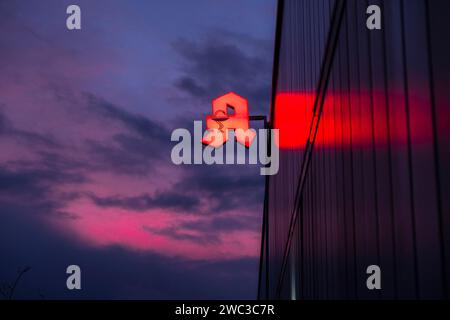 Beleuchtetes Apothekenschild vor stürmischem Himmel an einer Fassade in Düsseldorf Stockfoto