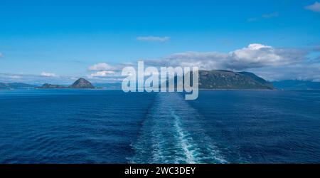 Blick am frühen Abend von einem Schiff, das sich von Sukkertoppen (die kleine Landmasse auf der linken Seite) und der Westspitze der Insel Sula auf der rechten Seite entfernt. Stockfoto