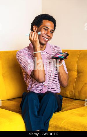 Fließender junger Mann, der zu Hause Crossdressing trägt, LGBTQ- und Diversity-Konzepte - hispanisches nicht binäres männliches Porträt in einer bunten Wohnung Stockfoto