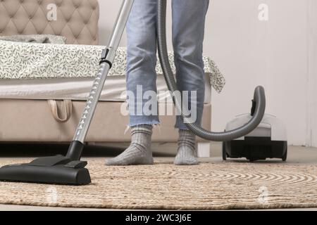 Hausfrau saugt das Zimmer, Hausleben, Wohnungsreinigungskonzept Stockfoto