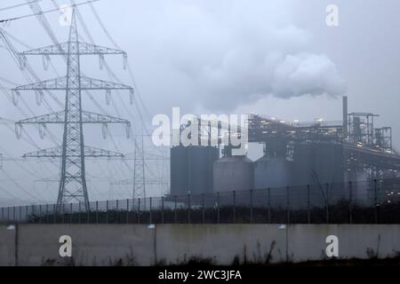 Strommasten stehen auf einem Feld in der Nähe von Industrieanlagen bei Köln. Unternehmen aus allen Branchen klagen über hohe Strompreise. Verschärft hat sich das seit dem Ukraine-Krieg und der darauf folgenden Energiepreiskrise. Themenbild, Symbolbild. Köln, 13.01.2024 NRW Deutschland *** Strommasten stehen auf einem Feld in der Nähe von Industrieanlagen in der Nähe von Köln Unternehmen aus allen Branchen beklagen sich über hohe Strompreise, die sich seit dem Krieg in der Ukraine und der darauffolgenden Energiepreiskrise verschlechtert haben. 13 01 2024 NRW Deutschland Copyright: xChristophx Stockfoto