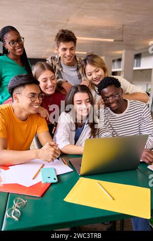 Eine große Gruppe junger multirassischer Schüler versammelte sich im Klassenzimmer, lächelte und beobachtete sie lustig Stockfoto