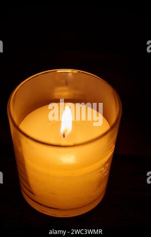 Nahaufnahme von brennender Kerze auf dunklem Hintergrund, Konzept des inneren Friedens Stockfoto