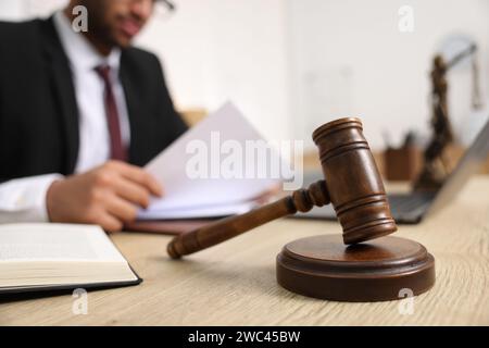 Der Anwalt arbeitet mit Dokumenten am Tisch im Büro, konzentriert sich auf den Hammer Stockfoto