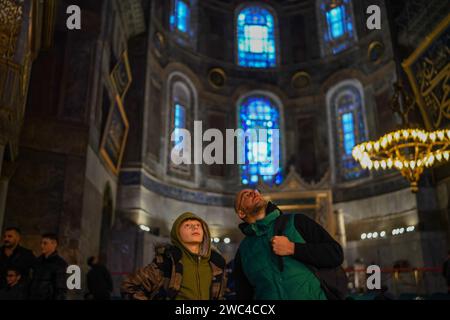 Istanbul, Türkei. Januar 2024. Touristen zeigen auf die Dekorationen an der Decke der Hagia Sophia. Die Hagia Sophia, wurde 2020 durch den Beschluss von Präsident Erdogan von einem Museum in eine Moschee umgewandelt, Besucher, die Touristen sind, werden ab 15. Januar 2024 eine Gebühr von 25 Euro, durch die Entscheidung des Ministeriums für Kultur und Tourismus. Quelle: SOPA Images Limited/Alamy Live News Stockfoto