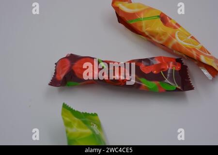 Helle natürliche Saugbonbons, Lutscher auf Sticks in farbiger Verpackung auf weißem Hintergrund. Stockfoto