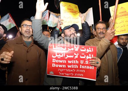 Bagdad, Irak. Januar 2024. Menschen mit Banner und Fahnen nehmen an einer Demonstration am 13. Januar 2024 auf dem Tahrir-Platz in Bagdad, Irak, Teil. Hunderte Iraker hielten am Samstag eine Kundgebung in der irakischen Hauptstadt Bagdad ab, um gegen die Angriffe der USA und Großbritanniens auf einige Militäreinrichtungen der Huthi im Jemen zu protestieren. Quelle: Khalil Dawood/Xinhua/Alamy Live News Stockfoto