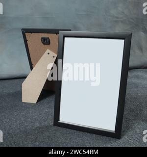 Leerer Bilderrahmen auf grauem Teppich im Zimmer, Stockfoto Stockfoto