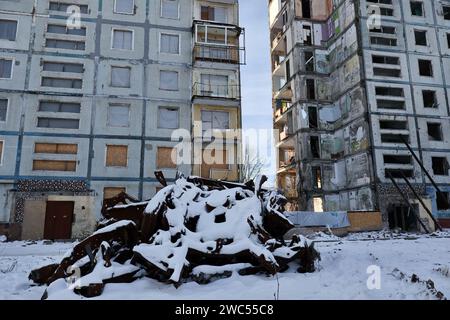 Zaporischzhia, Ukraine. Januar 2024. Ein zerstörtes Auto, das mit Schnee bedeckt ist, ist vor einem Wohngebäude zu sehen, das durch den russischen Beschuss in Zaporischschschi schwer beschädigt wurde. Der ukrainische Präsident Wolodymyr Zelenskij sagte, er sei jetzt positiver als im letzten Monat, dass sein Land neue finanzielle Hilfe von den USA erhalten würde. In Washington gab es jedoch keinen Hinweis darauf, dass die Zustimmung des Kongresses zu einem vom Weißen Haus vorgeschlagenen Hilfspaket in Kürze erfolgen würde. Quelle: SOPA Images Limited/Alamy Live News Stockfoto