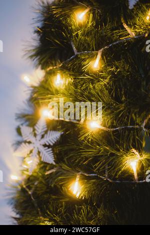 Ein festlicher Weihnachtsbaum mit einer Reihe funkelnder Lichter, die von oben kaskadiert und in Herzform angeordnet sind Stockfoto