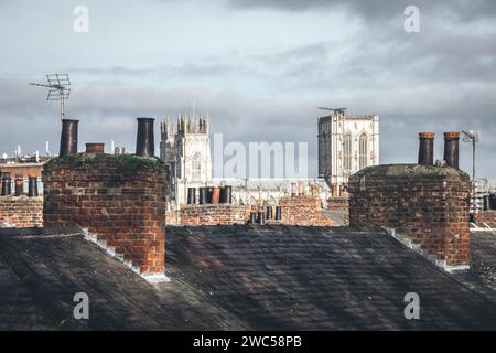 Blick auf das historische York Minster von den Dächern des Stadtzentrums von York, von den alten Stadtmauern aus gesehen. An einem bewölkten Tag mit Sonne. Stockfoto