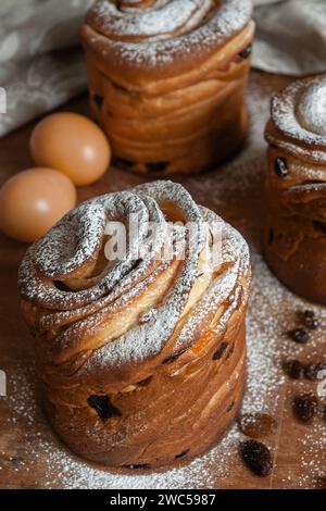 Osterkuchen Kraffins mit Rosinen, kandierten Früchten, bestreut mit Puderzucker. Nahaufnahme von hausgemachtem Kuchen. Cruffin. Ostereier Stockfoto