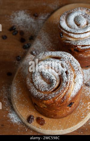 Frohe ostern. Traditionelle Osterkuchen, hausgemachte Kraffins mit Rosinen, kandiertes Obst. Selektiver Fokus. Nahaufnahme von hausgemachtem Cruffin. Hölzerne Backgrou Stockfoto