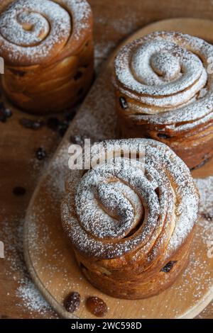 Frohe ostern. Traditionelle Osterkuchen, hausgemachte Kraffins mit Rosinen, kandiertes Obst. Selektiver Fokus. Nahaufnahme von hausgemachtem Cruffin. Hölzerne Backgrou Stockfoto