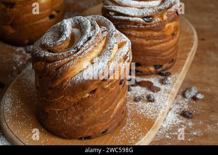 Frohe ostern. Traditionelle Osterkuchen, hausgemachte Kraffins mit Rosinen, kandiertes Obst. Selektiver Fokus. Nahaufnahme von hausgemachtem Cruffin. Hölzerne Backgrou Stockfoto