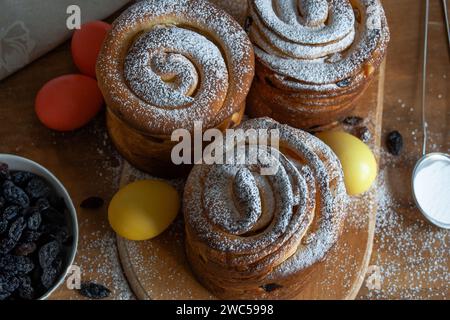 Osterkuchen Kraffins mit Rosinen, kandierten Früchten, bestreut mit Puderzucker. Nahaufnahme von hausgemachtem Kuchen. Cruffin. Ostereier Stockfoto