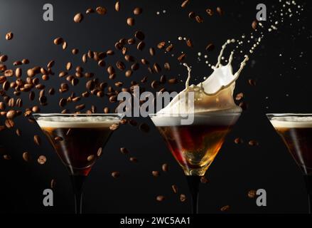 Espresso Martini-Getränk mit Spritzern und fallenden Kaffeebohnen auf schwarzem Hintergrund. Kopierbereich. Stockfoto