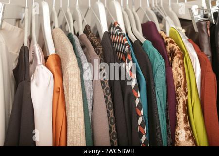Damenmode. Verschiedene Kleidung auf Kleiderbügeln, Nahaufnahme. Riesige Auswahl an verschiedenen gebrauchten Damenbekleidung auf dem Regal in einem Second-Hand-Shop oder in Second-Hand-s Stockfoto