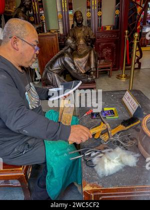 Peking, China, Porträt, Chinesischer Mann, der in einem traditionellen Schuhladen arbeitet, Demonstration von handgemachtem Kunsthandwerk, Qianmen-Viertel, lokaler Verkäufer, orientalischer Mann Stockfoto