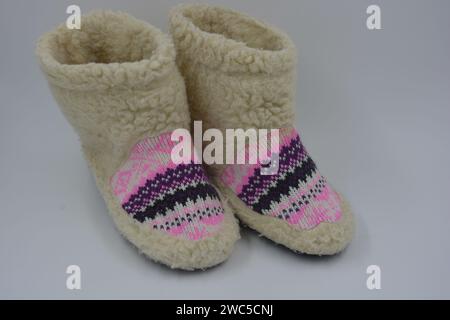 Schöne, warme Winterschuhe, Hausschuhe, Hausschuhe mit schwarzen Sohlen, hergestellt von ukrainischen Handwerkern aus natürlicher, leichter Wolle auf einem weißen. Stockfoto