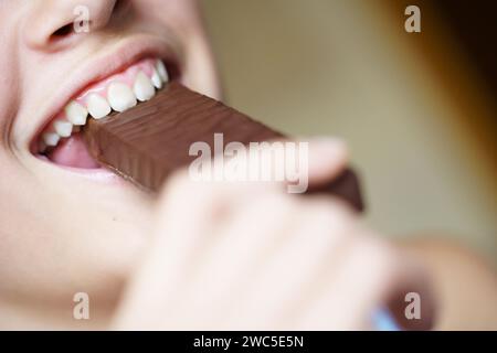 Glückliche Ernte anonymes Teenager-Mädchen beißt nahrhaften Proteinriegel Stockfoto