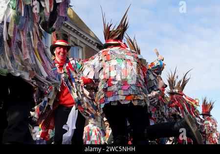 Morris-Tänzer treten auf, während der Strohbär während des Whittlesea Straw Bear Festival in Whittlesea, Cambridgeshire, durch die Straßen gleitet. Bilddatum: Samstag, 13. Januar 2024. Stockfoto