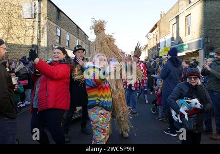 Der Strohbär wird während des Whittlesea Straw Bear Festivals in Whittlesea, Cambridgeshire, begleitet von Pflegern, Musikern und Tänzern durch die Straßen geführt. Bilddatum: Samstag, 13. Januar 2024. Stockfoto