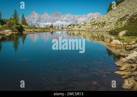 Einer der schönsten Bergseen Österreichs und majestätische hohe Dachsteinberge im Hintergrund. Der Spiegelsee in der Nähe von Schladming, Stockfoto