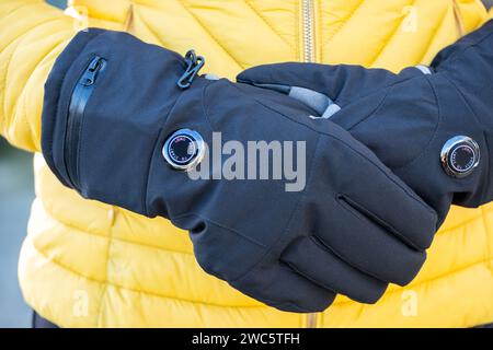 Eine Frau, die bei kaltem Wetter batteriebetriebene Handschuhe trägt. Die Handschuhe haben variable Wärmeeinstellungen und helfen denjenigen, die an der Reynauds-Krankheit leiden Stockfoto