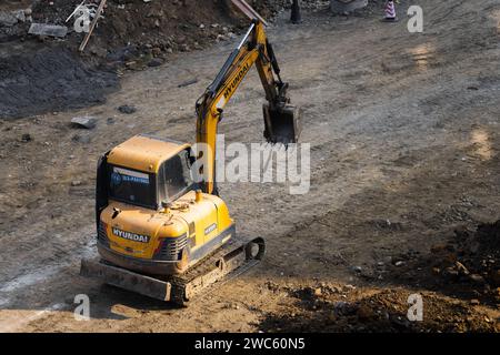 Der Bagger gräbt und transportiert am frühen Morgen Gegenstände Stockfoto