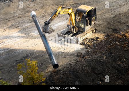 Der Bagger gräbt und transportiert am frühen Morgen Gegenstände Stockfoto