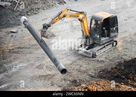 Der Bagger gräbt und transportiert am frühen Morgen Gegenstände Stockfoto