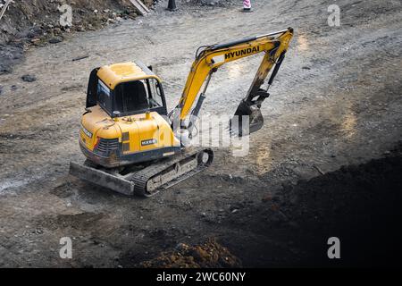 Der Bagger gräbt und transportiert am frühen Morgen Gegenstände Stockfoto