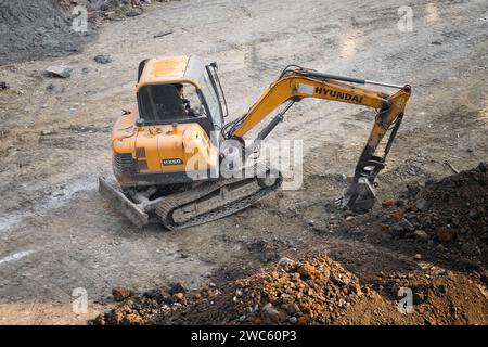 Der Bagger gräbt und transportiert am frühen Morgen Gegenstände Stockfoto