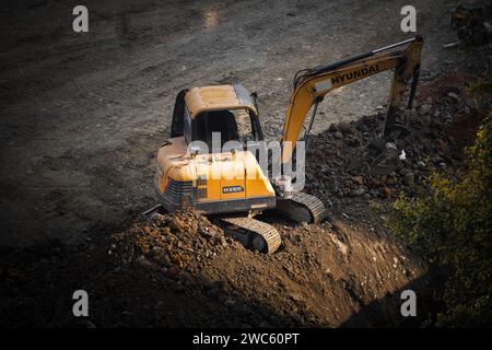 Der Bagger gräbt und transportiert am frühen Morgen Gegenstände Stockfoto